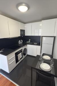 a kitchen with white cabinets and a table with plates on it at Appartement T2 à Neuilly in Neuilly-sur-Seine