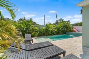a swimming pool with two chairs and a swimming pool at Tropical Disco-Groove Under Palms Where Disco Vibes meet Paradise in St Petersburg