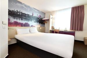 a bedroom with a large white bed and a desk at B&B Hotel Warszawa-Okęcie in Warsaw +45 photos