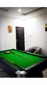 a pool table in a room with a door at A1 Pinnacle Serviced Apartment in Oshogbo +2 photos