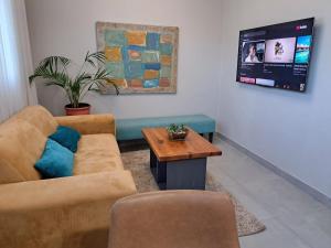 a living room with a couch and a table at Hadeda Cottage in Johannesburg