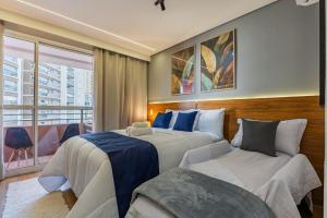 a hotel room with two beds and a window at Studio Conforto a 15Min da USP e perto do mêtro butantã in São Paulo