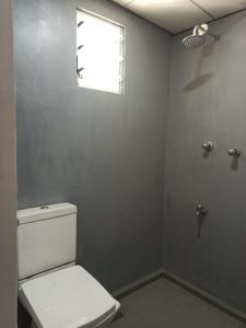 ターラ・サウにあるGreen Villa Talallaの白いトイレと窓のあるバスルーム
