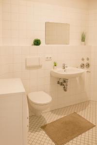 a white bathroom with a toilet and a sink at SUNNYHOME Monteurwohnungen und Apartments in Weiden in Weiden