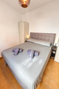 1 cama blanca grande con 2 almohadas moradas. en Palma79-Kira, en Águilas