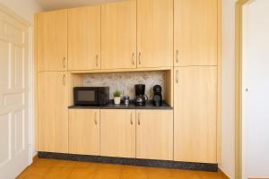 Una cocina con gabinetes de madera y microondas. en Palma79-Kira, en Águilas 16 fotos más