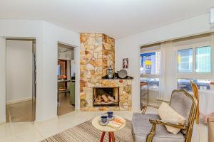 a living room with a stone fireplace and a couch at Mar a Lago - Beira Mar Barra Velha - 4 Quartos in Barra Velha