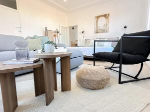 a living room with a couch and a table and a bed at CBD Studio - Sleeps 4 - Rooftop Courtyard - Views in Wollongong