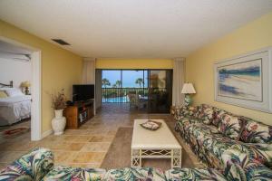 un soggiorno con un divano e un tavolo di Breathtaking beach views await from this 2BR 2nd floor condo on Longboat Key The Beach Fact Oar a Longboat Key