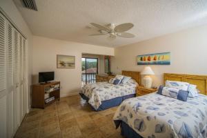 una camera da letto con due letti e un ventilatore a soffitto di Breathtaking beach views await from this 2BR 2nd floor condo on Longboat Key The Beach Fact Oar a Longboat Key Altre 23 foto