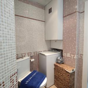 a small bathroom with a toilet with a blue seat at VILLAS COSETTE Apartamento NEPTUNO 224 ALQUILER TEMPORAL 
