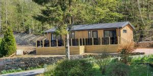 een kleine houten hut midden in een bos bij High Spy Luxury Lodge in Keswick +2 foto's