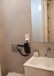 a bathroom with a phone on the wall next to a sink at Studio Ten in Thessaloniki
