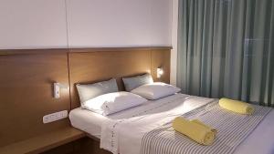 a bedroom with a large bed with a yellow folder on it at Studio Ten in Thessaloniki