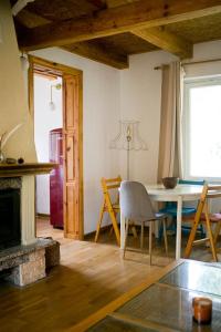 a living room with a table and a fireplace at Przytulny dom w sosnowym lesie nad rzeką i jeziorem in Rolbik
