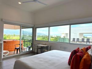 a bedroom with a bed and a view of a balcony at Papaya Condo Acapulco Diamante -Solo Adultos in Acapulco +106 photos