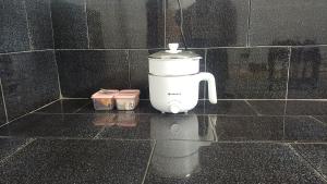 a white blender sitting on a tiled wall at THEERTHAMKARA Staycation in Nīleshwar