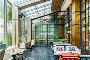 - un hall avec des tables, des chaises et des fenêtres dans l'établissement Montien Hotel Surawong Bangkok, à Bangkok