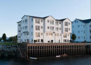un edificio en un muelle con barcos en el agua en Modern & Elegant Apartment in Henningsvær, en Henningsvaer