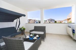 ein Wohnzimmer mit einem Tisch und Stühlen auf dem Balkon in der Unterkunft Apartments New home in Vodice