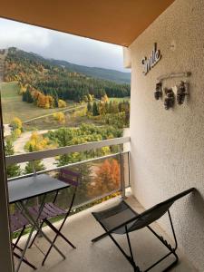 een tafel en een stoel op een balkon met uitzicht bij Avec balcon, au pied des pistes et randos in Villard-de-Lans