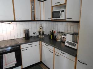 a kitchen with white cabinets and a black counter top at Dornbirn Zentrum Bahnhof in Dornbirn
