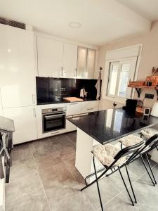 a kitchen with white cabinets and a black counter top at APARTAMENTO PRECIOSO SOL Y SIERRA in Sierra Nevada