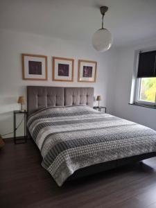 a bedroom with a large bed with a gray comforter at Bizette67 in Herstal