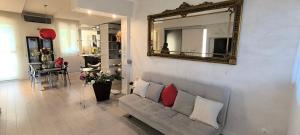 a living room with a couch and a mirror at Appartamento incantevole con parcheggio gratuito in Florence