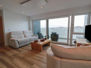 a living room with two couches and a large window at Lazy Bulldog in Newport-On-Tay