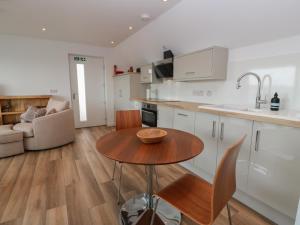 a kitchen and living room with a wooden table at Lazy Bulldog in Newport-On-Tay +13 photos