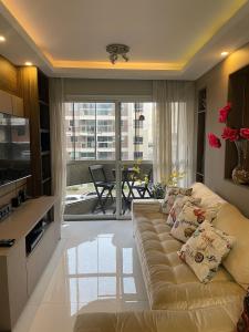 a living room with a couch and a kitchen at Batel Guest House in Curitiba