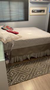 a bed sitting in a room with a floor at Batel Guest House in Curitiba