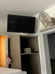 een flatscreen-tv aan het plafond van een slaapkamer bij Avec balcon, au pied des pistes et randos in Villard-de-Lans