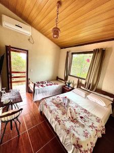 a hotel room with two beds and a table and a table sidx sidx at Pousada Mangaba da Serra in Serra do Cipo +24 photos