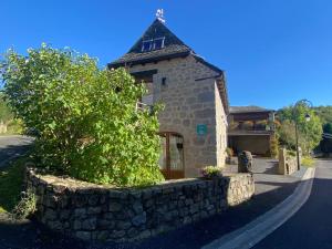 a small stone building with a stone wall at Gîte de la Taouyre in Saint-Symphorien-de-Thénières