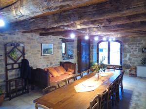 a living room with a wooden table and a couch at Gîte de la Taouyre in Saint-Symphorien-de-Thénières