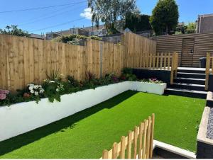 ein Garten mit einem Holzzaun und grünem Gras in der Unterkunft Spacious 3BR Swansea House near City Centre in Swansea