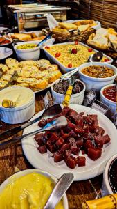 a table with many different types of food on plates at Navega Praia Casa in Navegantes