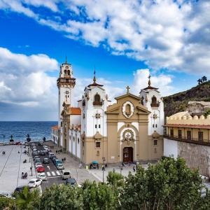 a large building next to a parking lot in front of the ocean at Candelaria Sea Music in Candelaria
