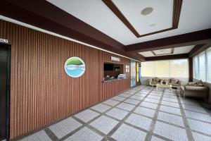 a lobby with a couch and a tv on a wall at Palm Cabanas Resort in Arayat