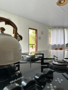 a tea kettle on top of a stove in a kitchen at Beira Rio Casa Canastra in Vargem Bonita