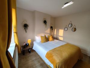 a bedroom with a bed with yellow and white sheets at Peak District Cottage Sleeps 6, Parking and Projectors in all the Rooms in Buxton