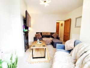 a living room with a couch and a table at Peak District Cottage Sleeps 6, Parking and Projectors in all the Rooms in Buxton