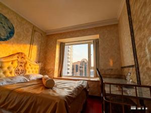 Un dormitorio con una cama con ventana y un escritorio. en Panoramic views of the Bund and the Yangtze River, adjacent to the Oriental Pearl Tower, a top-tier luxury residence in Shanghai, en Shanghái