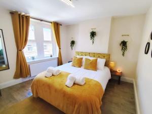 a bedroom with a bed with two towels on it at Peak District Cottage Sleeps 6, Parking and Projectors in all the Rooms in Buxton +19 photos