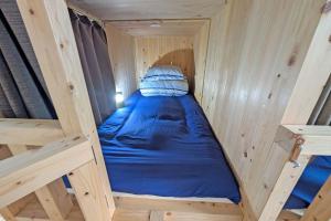 Ένα ή περισσότερα κρεβάτια σε δωμάτιο στο 木製ぬくもりカプセル宿