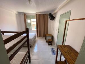 a small room with a bed and a staircase at Hospedagem Raiz Vida in Itacaré