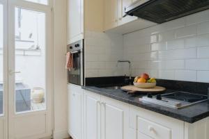 a kitchen with a sink and a bowl of fruit on a counter at Urban Hideout Just Steps from Antwerp's Highlights in Antwerp