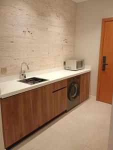 a kitchen with a washing machine and a microwave at Samt Residence - LUX apartments in Quai